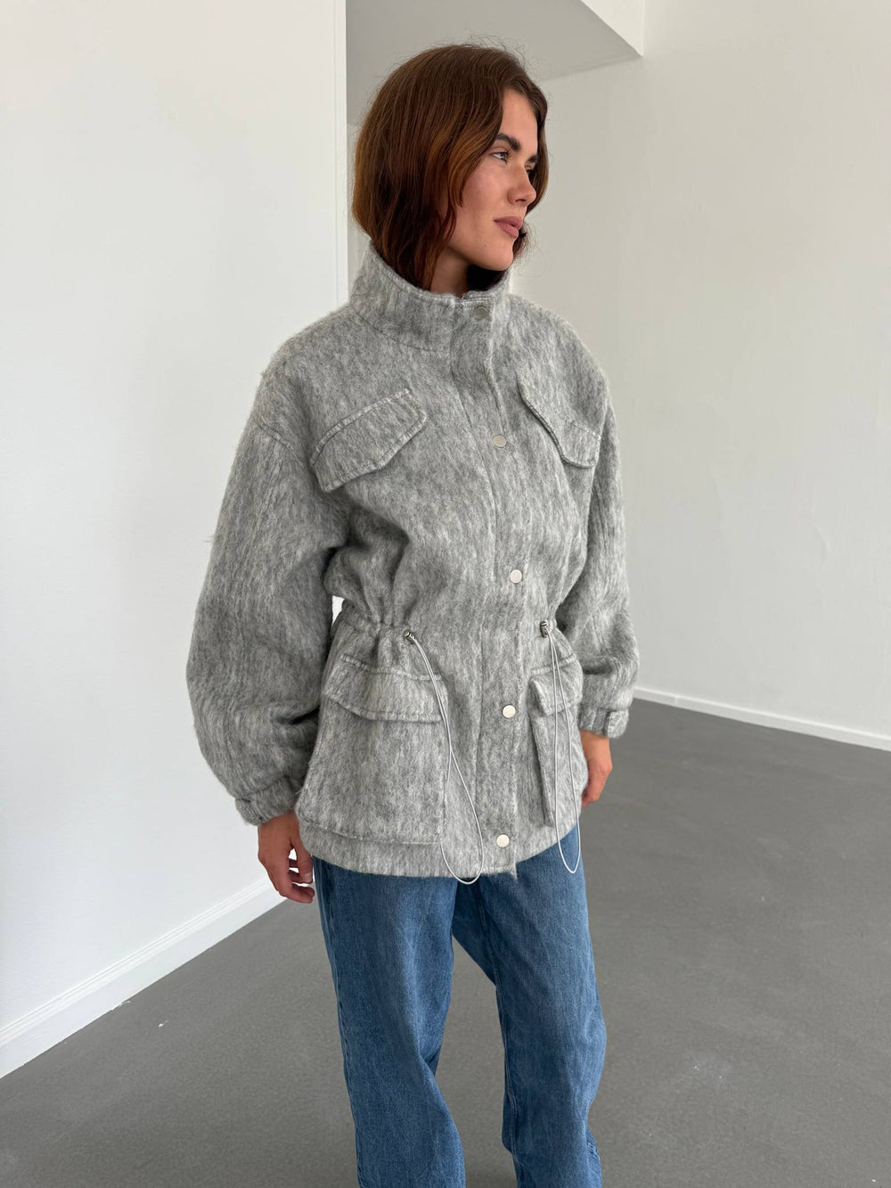 Grå MEOTINE jakke med lommer og justerbar talje, perfekt til en stilfuld og komfortabel look.