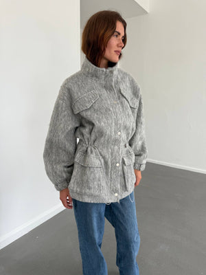 Grå MEOTINE jakke med lommer og justerbar talje, perfekt til en stilfuld og komfortabel look.