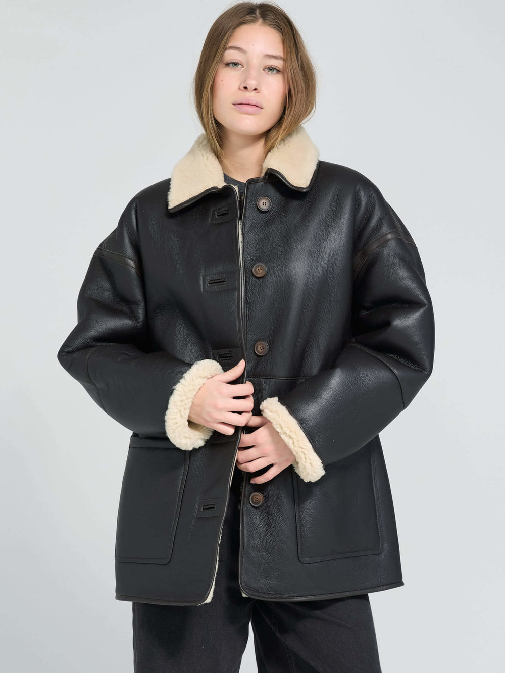 MEOTINE jakke i sort læder med blødt pelsfor, perfekt til stilfulde og varme outfits.