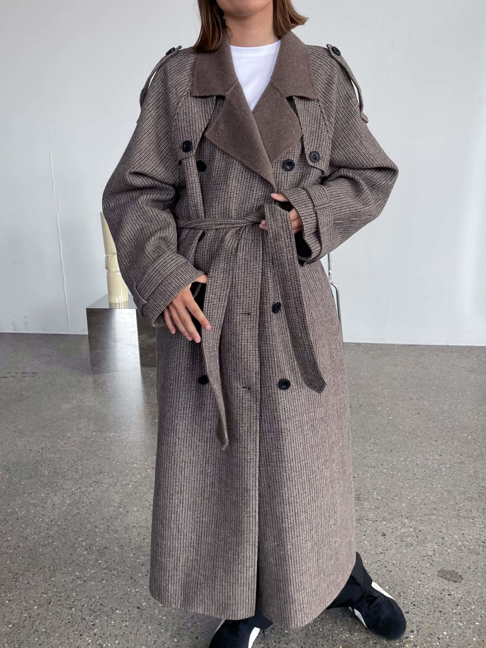 Lang, brun MEOTINE frakke med bælte og klassisk trench coat design, perfekt til efteråret.