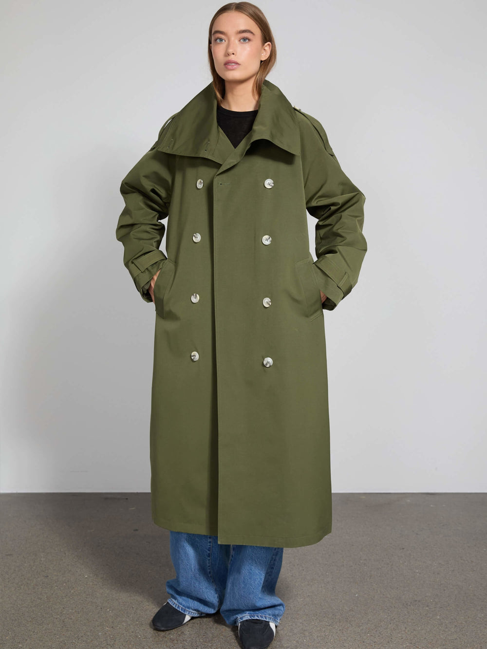 Lang, olivengrøn trenchcoat fra MEOTINE med dobbeltknaplukning og rummelige lommer.