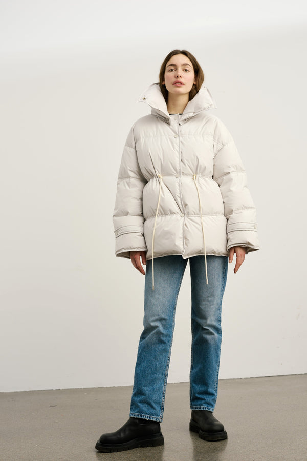 MEOTINE pufferjakke i lys beige med justerbar talje og moderne design til koldt vejr.