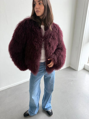 Lækker, fluffy bordeaux jakke fra MEOTINE, stylet med en hvid top og løse jeans, perfekt til en trendy look.
