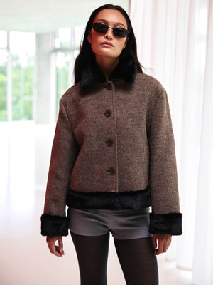 Brun uldjakke med faux fur detaljer og knaplukning, perfekt til en stilfuld MEOTINE look. Model bærer solbriller.