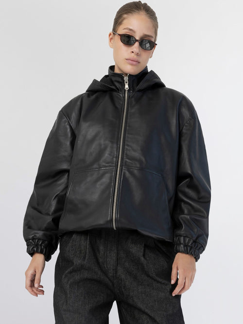 Sort læderjakke med hætte og elastiske manchetter, perfekt til en moderne og stilfuld look fra MEOTINE.