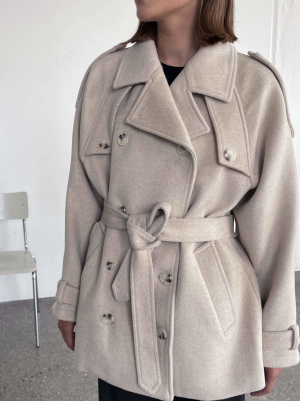 Beige frakke med bælte og dobbeltknaplukning, perfekt til efteråret. MEOTINE tilføjer stil og komfort til din garderobe.