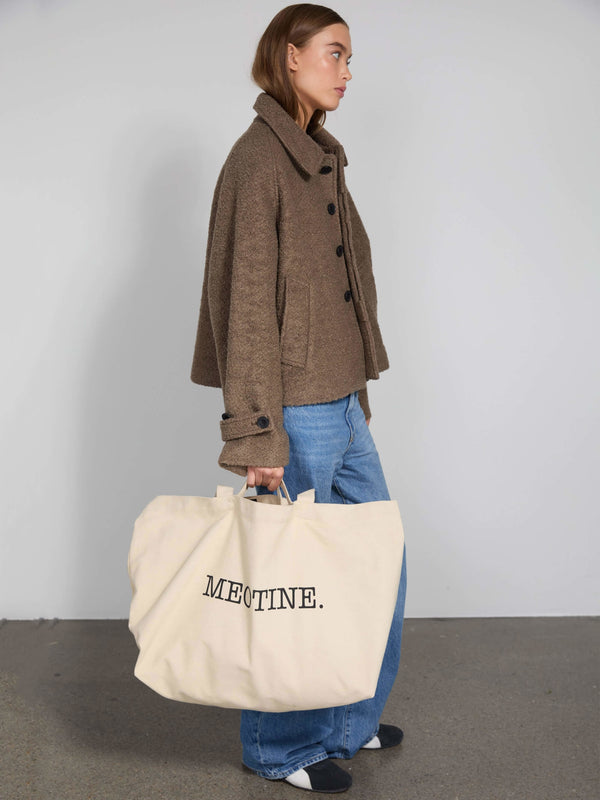 Brun jakke med knapper og løs pasform, bæres sammen med en stor MEOTINE taske i beige, perfekt til hverdagsbrug.