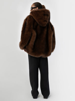 Brun, fluffy hoodie fra MEOTINE, med hætte og løs pasform, kombineret med sorte, brede bukser for et stilfuldt look.