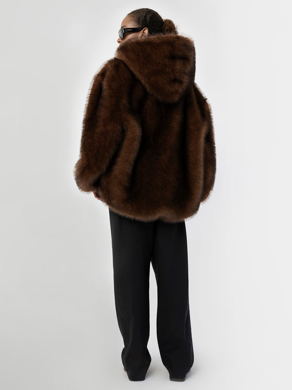 Brun, fluffy hoodie fra MEOTINE, med hætte og løs pasform, kombineret med sorte, brede bukser for et stilfuldt look.