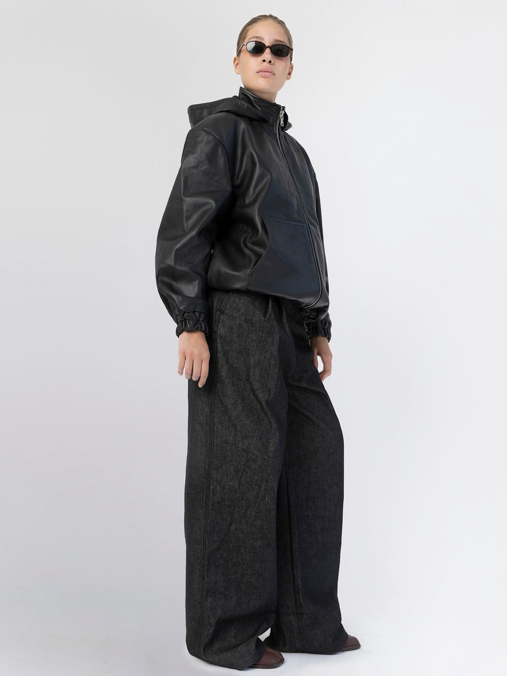 Sort læderjakke med hætte og elastiske manchetter, perfekt til en moderne og stilfuld look fra MEOTINE.