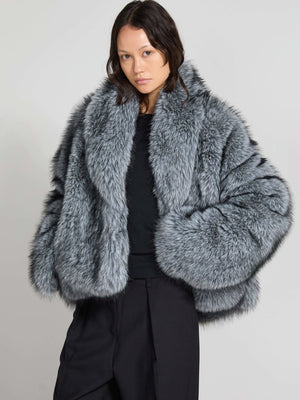 Grå, fluffy jakke fra MEOTINE, der giver et elegant og varmt look. Modellen bærer den med stil og selvsikkerhed.