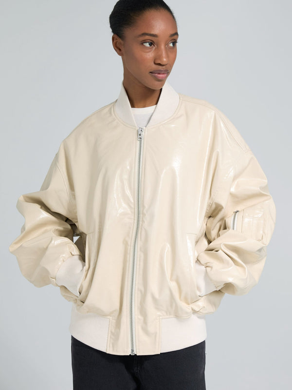 MEOTINE jakke i lys beige med glansfuld finish og oversized pasform, perfekt til enhver lejlighed.