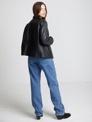 Sort læderjakke med afslappet pasform, kombineret med lyse jeans. Perfekt til en moderne og stilfuld garderobe fra MEOTINE.