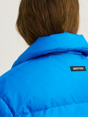 Blå jakke med høj krave og MEOTINE-logo, set fra ryggen, fremhæver en moderne og stilfuld look.