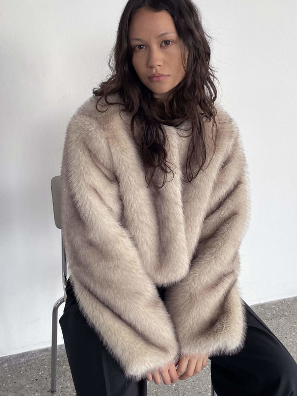 Lys beige MEOTINE sweater med brede ærmer, bådudskæring og en blød, fluffy tekstur, båret af en model i en minimalistisk setting.