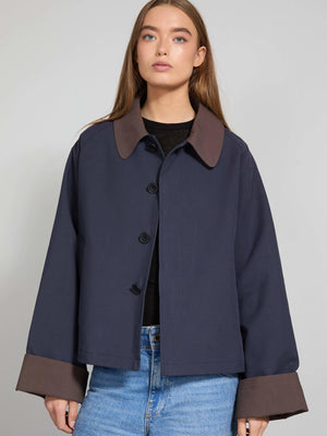 Mørkeblå jakke med brune detaljer og knaplukning, perfekt til en afslappet stil. MEOTINE tilføjer et moderne touch.