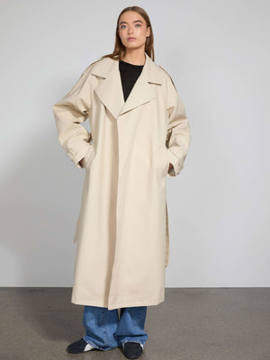 Lang beige trenchcoat med store lommer og oversize pasform, perfekt til en stilfuld og moderne garderobe fra MEOTINE.