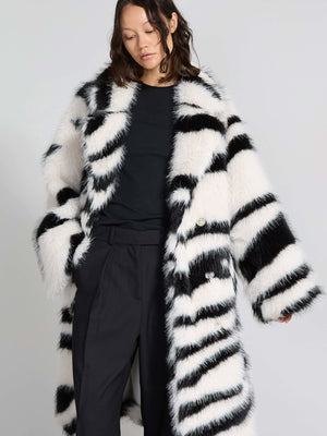 Lang, stribet frakke i sort og hvid fra MEOTINE, med en blød, fluffy tekstur og store knapper, perfekt til vinteren.