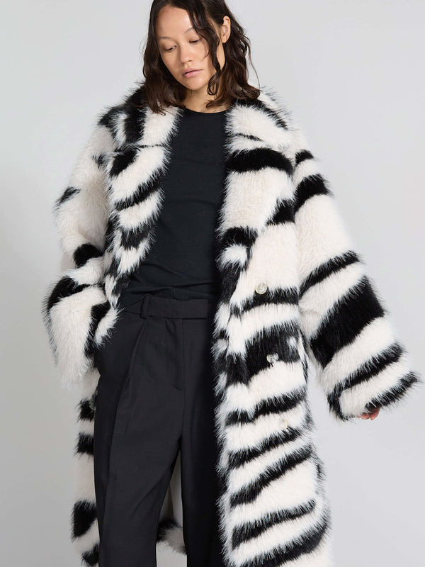 Lang, stribet frakke i sort og hvid fra MEOTINE, med en blød, fluffy tekstur og store knapper, perfekt til vinteren.