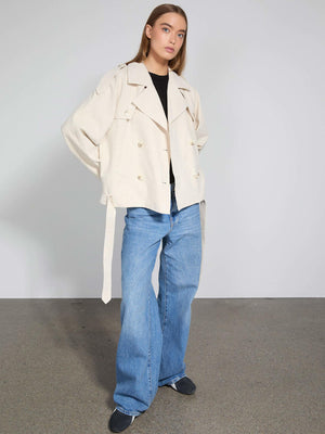 Lys beige jakke med dobbeltradet knaplukning og bælte, parret med løse jeans, fra MEOTINE. Elegant og moderne stil.